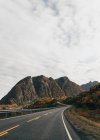 Estrada curvilínea vazia que leva em montanhas — Fotografia de Stock