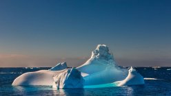 Scenic view of floating in sea iceberg over sunset sky — Stock Photo
