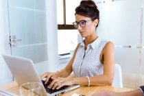 Portrait of  businesswoman working with laptop in modern office. — Stock Photo