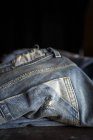 Close up vista de calças de calça azul casual na mesa escura . — Fotografia de Stock