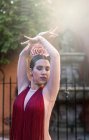 Танцовщица фламенко позирует в красном платье на освещенных солнцем улицах — стоковое фото