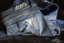Close up vista de calças de ganga azul na mesa escura . — Fotografia de Stock