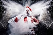Santa Claus in middle of snow explosion — Stock Photo