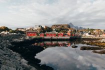 Vista lejana de la pequeña ciudad costera con casas rojas en la orilla del lago - foto de stock