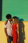 Portrait de couple embrassant posant près de la façade du bâtiment de la plage — Photo de stock