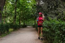 Спортсменка ходить з пляшкою води після тренування в парку — стокове фото