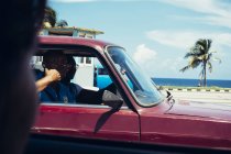CUBA - AUGUST 27, 2016:People gesturing in car passing by camera at road — Stock Photo