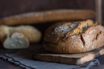 Vista de nível de superfície de loafs de pão caseiros na mesa rústica . — Fotografia de Stock