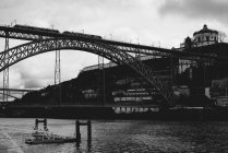 Metal railway bridge construction above river in city. — Stock Photo