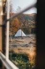 Vue à travers la fenêtre de la tente placée dans le jardin d'automne . — Photo de stock