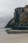 Scenic view of massive rocky cliffs on seashore on cloudy day. — Stock Photo