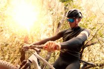 Vista lateral del hombre en bicicleta en el bosque - foto de stock