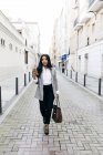 Élégante femme d'affaires marchant avec téléphone dans la rue — Photo de stock