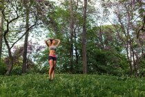 Спортсменка блондинка позує на газоні в міському парку — стокове фото