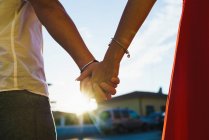 Crop hands of couple posing in bright sunlight at street scene — Stock Photo