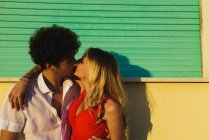 Liebevoll umarmendes Paar küsst sich vor Straßenfassade — Stockfoto