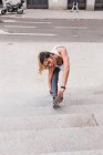 Vue de face de la femme sportive étirant la jambe aux escaliers — Photo de stock