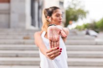 Спортивна жінка розігріває руку на вулиці — стокове фото