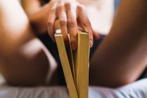 Cortar mão feminina provocante posando com livro — Fotografia de Stock