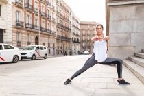 Mujer deportiva realizando yoga asana en la calle - foto de stock