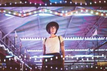Hochwinkel-Porträt einer Frau, die im beleuchteten Nachtpark posiert — Stockfoto