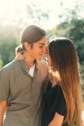Retrato de jovem casal abraçando cara a cara em tempo ensolarado ao ar livre. Efeito Blacklit. — Fotografia de Stock