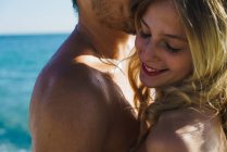 Crop uomo abbracciando giovane moglie su oceanscape su sfondo — Foto stock