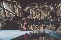 Чарівна коричнева собака-лабрадор сидить на сходах, проходячи через сучасний архітектурний фасад — стокове фото