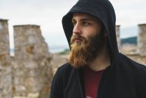 Portrait of bearded man in hood looking away — Stock Photo