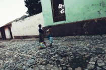 CUBA - AUGUST 27, 2016: Side view of two women standing on paved street in poor district and chatting. — Stock Photo