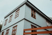 Low angle view of wooden white house facade with brown windows — Stock Photo