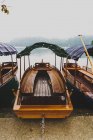 Пустая пришвартованная лодка с навесом ткани на берегу озера — стоковое фото