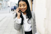 Portrait of elegant businesswoman talking on phone at street scene — Stock Photo