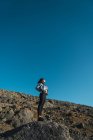Vista basso angolo di donna in piedi su pendio roccioso — Foto stock