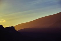 Montañas siluetas pastel sobre el cielo puesta del sol - foto de stock