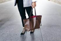 Low section of woman with handbag on street — Stock Photo