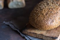 Закрыть домашнюю буханку хлеба деревянной доской . — стоковое фото