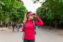 Спортивная бегунья с рюкзаком позирует в летнем парке — стоковое фото