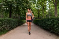 Sportswoman con zaino a piedi sul vicolo del parco — Foto stock