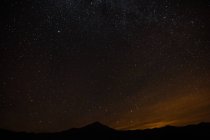Paisaje con montañas y estrellas en el cielo nocturno - foto de stock