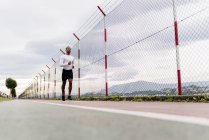 Vista superficiale dell'atleta che corre lungo la recinzione — Foto stock