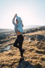 Seitenansicht brünettes Mädchen balanciert auf Stein auf dem Land Feld — Stockfoto