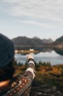 Over shoulder view of woman pointing away at lake in mountains. — Stock Photo