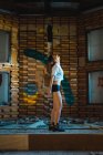 Seitenansicht des brünetten Mädchens posiert in lässiger Kleidung in verlassenen dais — Stockfoto
