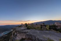 Vista a distanza del villaggio in cima alla montagna pianeggiante sullo sfondo della valle al tramonto — Foto stock