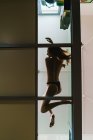 Vista inferior da mulher de topless deitado no chão de vidro — Fotografia de Stock