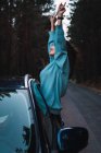 Seitenansicht einer glücklichen Frau, die sich aus dem Autofenster lehnt — Stockfoto