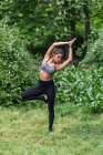 Konzentrierte Frau führt Yoga-Asana und Meditation im Park durch — Stockfoto