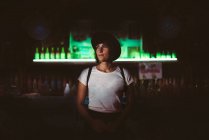 Впевнена жінка позує в барі і дивиться вбік — стокове фото