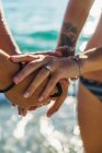Crop couple in swimsuit holding hands with wedding rings — Stock Photo